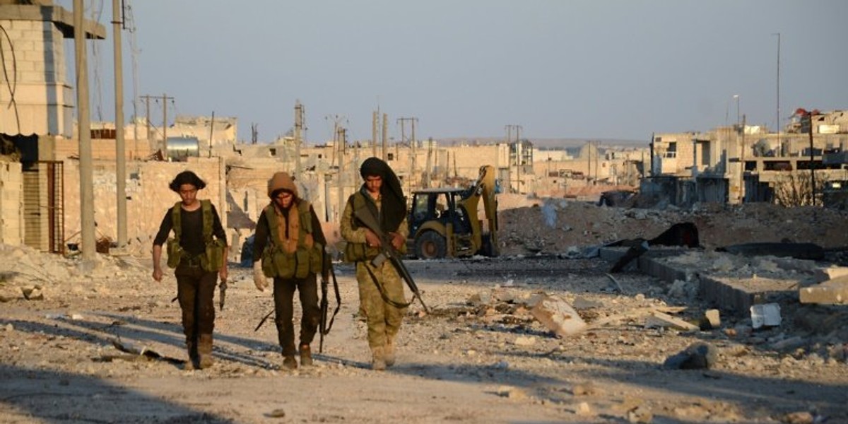 Turkish-backed Syrian rebels patrol through the town of al-Bab shortly after they captured it from ISIS.