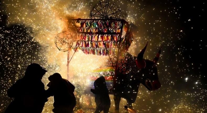 People run away from fireworks exploding around them next to a traditional torito (little bull) made of paper, wood and fireworks, during the San Juan de Dios festival in Tultepec, on March 8, 2017