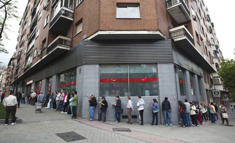 Bezrobotni stoją w kolejce do urzędu pracy w Madrycie