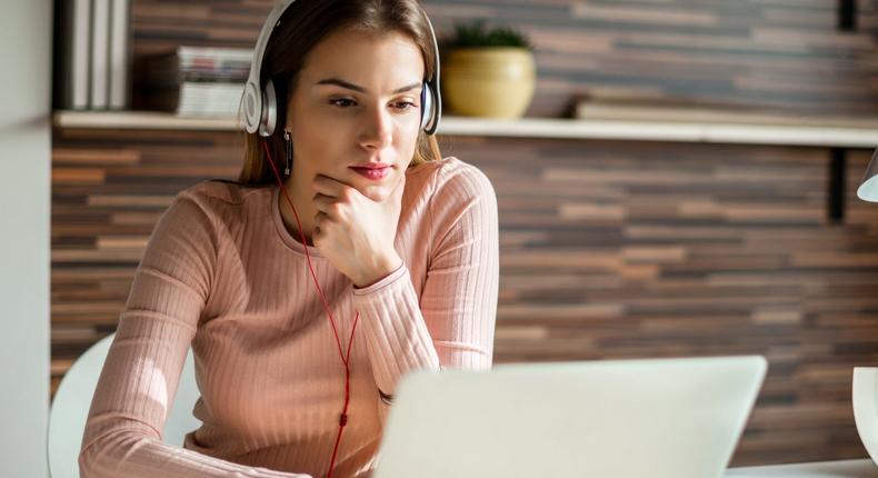 A woman enjoying music while working in the office.
