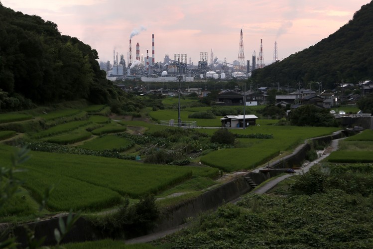 Kominy fabryk z kompleksu przemysłowego Mizushima kontrastują z rolniczym krajobrazem pól i domów jednorodzinnych w prefekturze Okayama w Japonii. W drugim kwartale tego roku największe japońskie spółki podwoiły swoje zyski  w porównaniu z tym samym okresem ubiegłego roku, wspierając tym samym <a href=' http://forsal.pl/artykuly/709294,polityka_gospodarcza_japonii_czyli_wszystkie_pomysly_premiera_shinzo_abe.html'>wysiłki premiera Shinzo Abe zmierzające do ożywienia gospodarki</a> tego kraju. Fot. Kiyoshi Ota, Bloomberg's Best Photos 2013.
