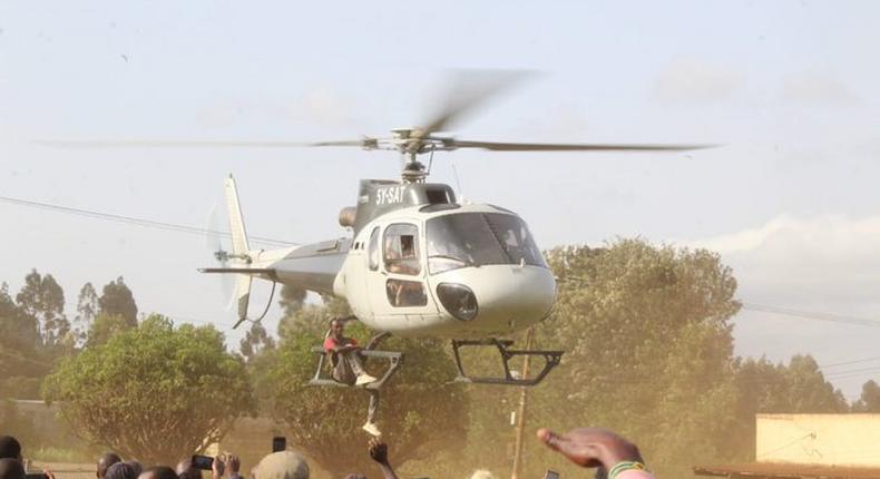 Joakim Mutwiri hanging on CS Munya's chopper