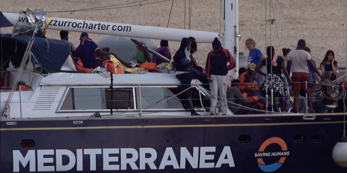 A still image from a video footage shows migrants sitting on board of a migrant rescue boat "Alex", after the vessel docked at the port of Lampedusa in defiance of a ban on entering Italian waters, in Lampedusa