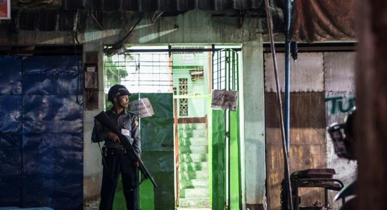 A policeman secures the entrance to the immigration office in South Dagon, a suburb of Yangon, following multiple explosions on November 24, 2016
