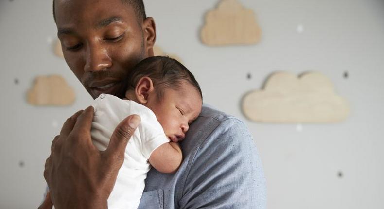 A daddy holding his new born baby. 