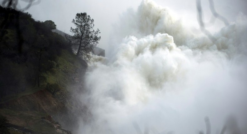 Water rushes down a spillway as an emergency measure at the Oroville Dam in Oroville, California on February 13, 2017