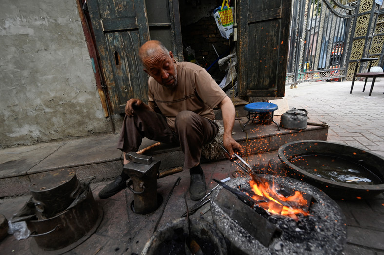 Ujgurski mężczyzna wykonujący prace kowalskie w Sinciangu, lipiec 2023 r.