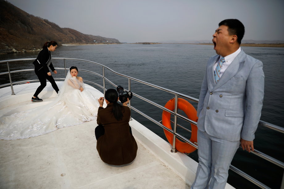 A couple gets ready for their wedding photo session on a boat that takes tourists from Chinese side of the Yalu River close to the shores of North Korea.