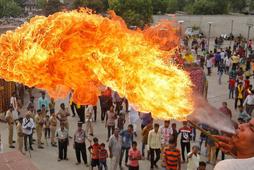 A Hindu devotee performs a stunt with fire during the Jal Yatra procession ahead of the annual Rath Yatra, or chariot procession, which will be held on June 25, in Ahmedabad