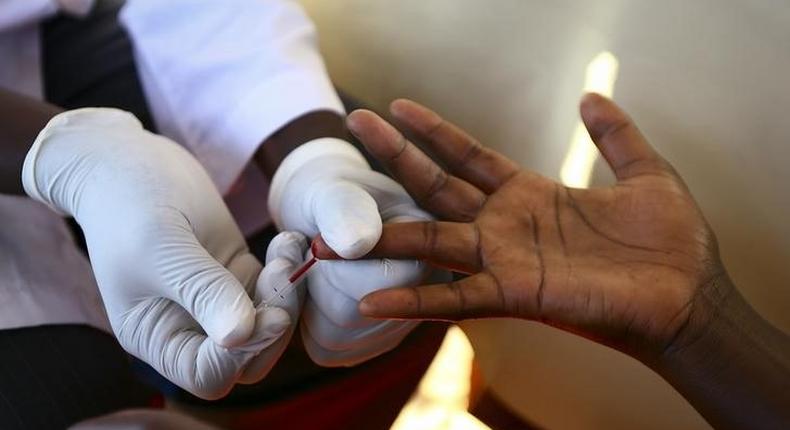 A doctor draws blood from a man to check for HIV/AIDS at a mobile testing unit in Ndeeba, a suburb in Uganda's capital Kampala May 16, 2014. 
