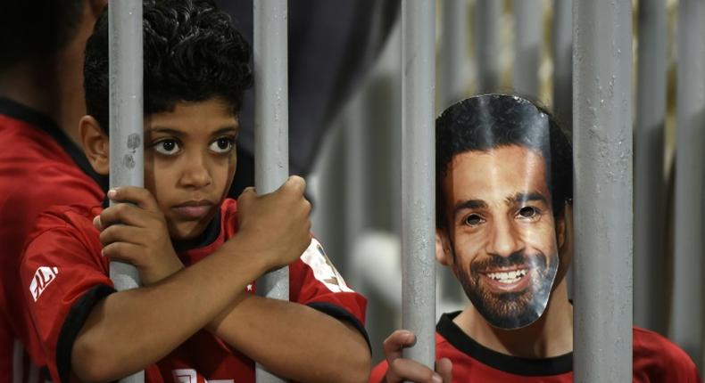A fan wearing a mask of Egyptian football star Mohamed Salah poses for a photograph prior to the 2019 Africa Cup of Nations qualifier between Egypt and Niger on September 8, 2018 at the Borg el-Arab stadium near the Mediterranean city of Alexandria