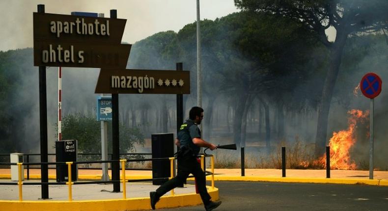 A Guardia Civil officer battling a wildfire near Mazagon in southwestern Spain, which has forced more than 2,000 people to evacuate the area