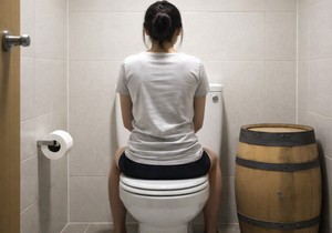 Žena sedi na WC šolji, ilustracija