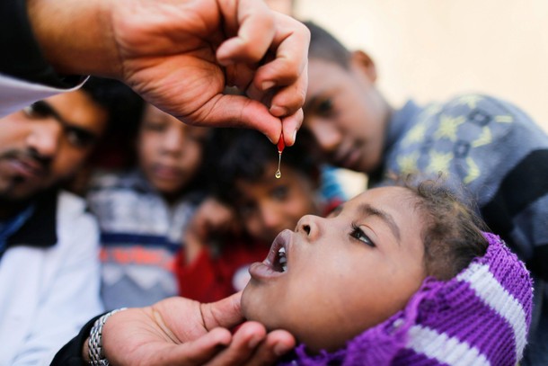 Girl is given vitamin A drops during a house-to-house vaccination campaign in Sanaa