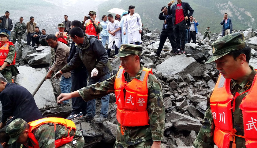 People search for survivors at the site of a landslide that occurred in Xinmo Village