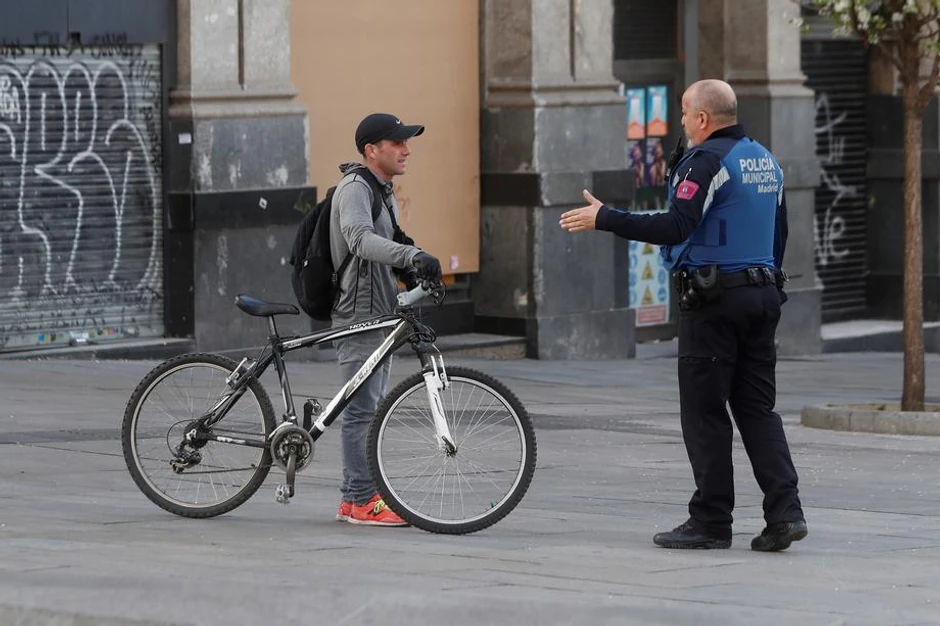 Policajac objašnjava da je zabranjena vožnja bicikle u Madridu zbog korona virusa