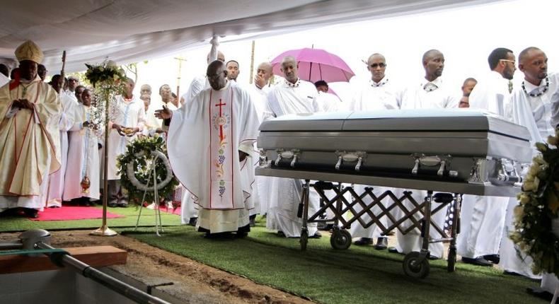 A priest gestures by the coffin of late King Kigeli V Ndahindurwa as relatives and friends attend the funeral service on January 15, 2017 in Nyanza