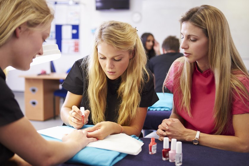 Teacher Helping Students Training To Become Beauticians