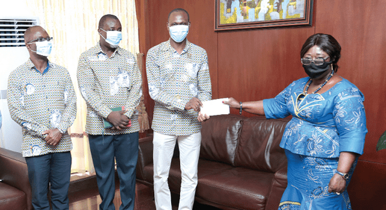 Mrs Akosua Frema Osei Opare receiving a cheque from Dr John Amaglo President, Ghana Institute of Surveyors