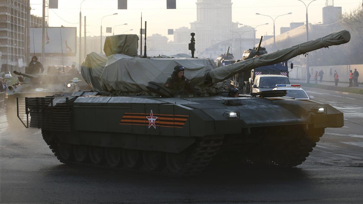 Russian servicemen drive a partially covered T-14 Armata tank along a street before a rehearsal for the Victory Day parade in Moscow