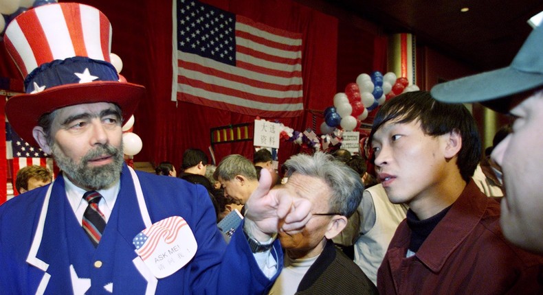 Jon Zatkin of San Francisco, dressed as Uncle Sam, tells Chinese guests about the US presidential election during a reception held by the US Embassy in Beijing on November 8, 2000.