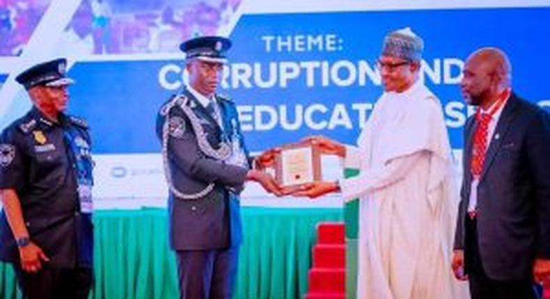 CSP Daniel Amah (left) receiving an award from President Muhammadu Buhari