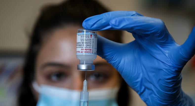 A NHS vaccinator prepares to administer the Moderna Covid-19 vaccine to a member of public at a vaccination centre in London.
