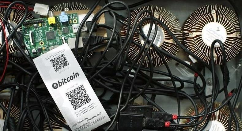 A Bitcoin (virtual currency) mining machine and a paper wallet with QR codes are seen in an illustration picture taken at La Maison du Bitcoin in Paris