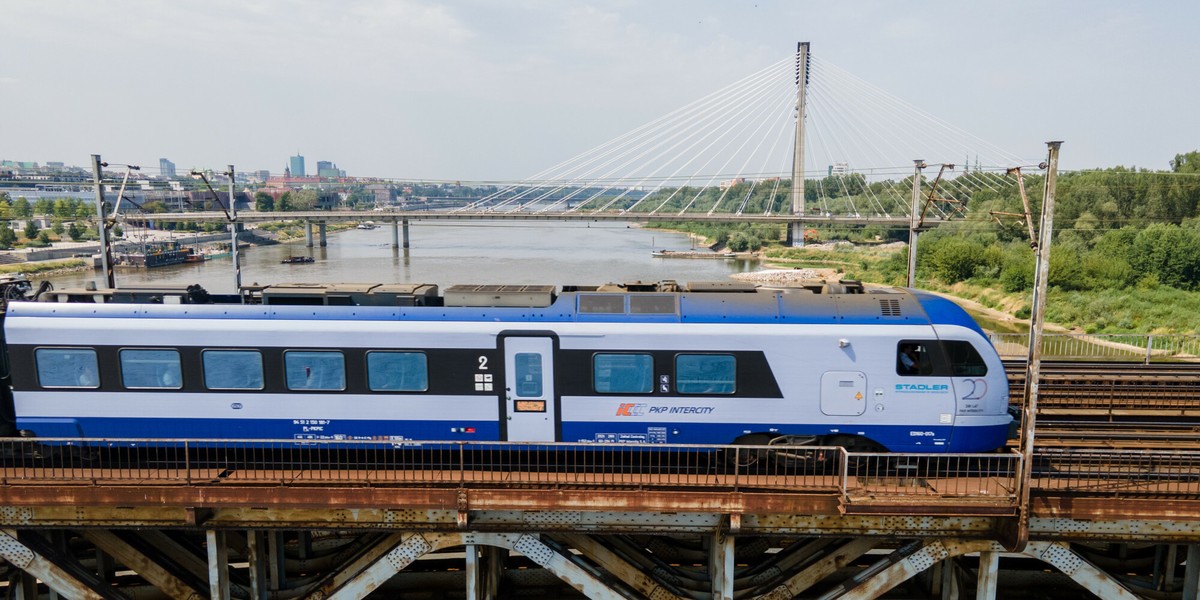 Pociąg Intercity przejeżdżający przez most w centrum Warszawy.