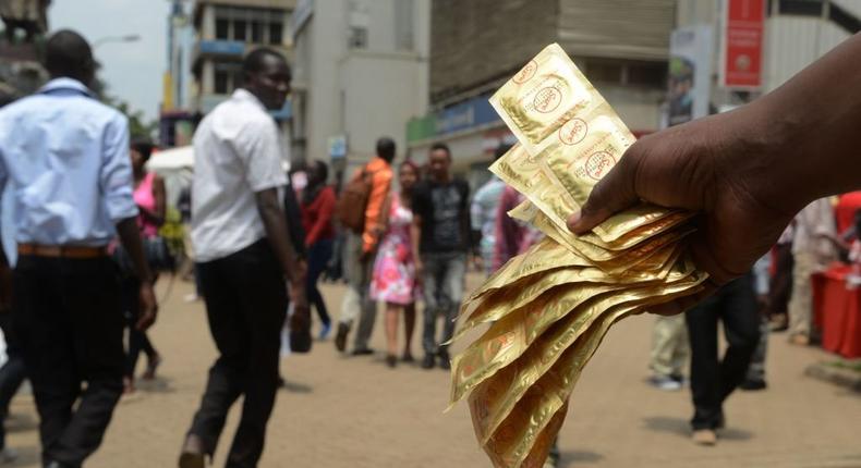 [FILE] An Aids Healthcare Foundation-Kenya worker distributes condoms in the streets of Nairobi on February 14, 2014 to promote safe sex practices during the Valentine week and to mark the International Condom Day. (Photo by  SIMON MAINA/AFP via Getty Images)
