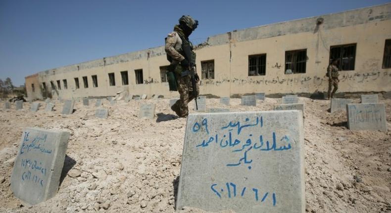 Iraqi soldiers check a cemetery where jihadists of the Islamic State (IS) group were buried in Fallujah