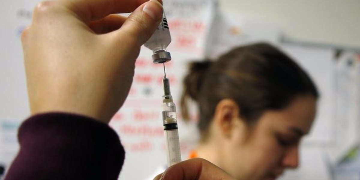 Nurses prepare influenza vaccine injections during a flu shot clinic in Boston