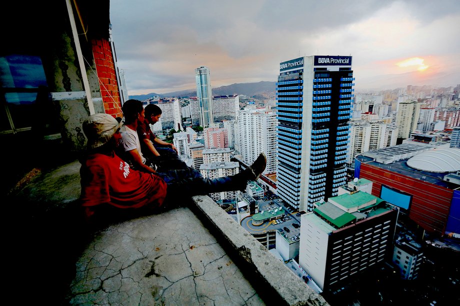 Men rest after salvaging metal on the 30th floor of the "Tower of David" skyscraper in Caracas, February 3, 2014. The 45-story skyscraper was meant to be financial center, but since its abandonment in 1994, it's become slum, probably the highest in the world.