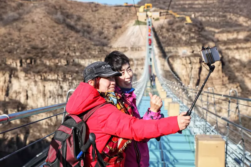 Turyści robią sobie selfie na moście