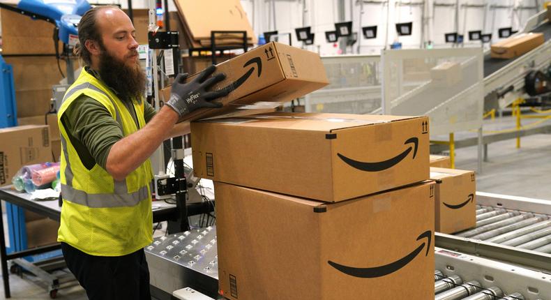 An Amazon worker stacks packages.