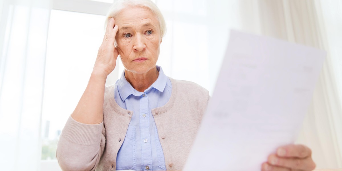 senior woman with papers and calculator at home