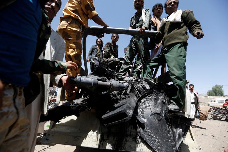 Militantes hutíes recogen partes de un dron que los rebeldes hutíes dijeron haber derribado en Saná, Yemen, el 1 de octubre de 2017.