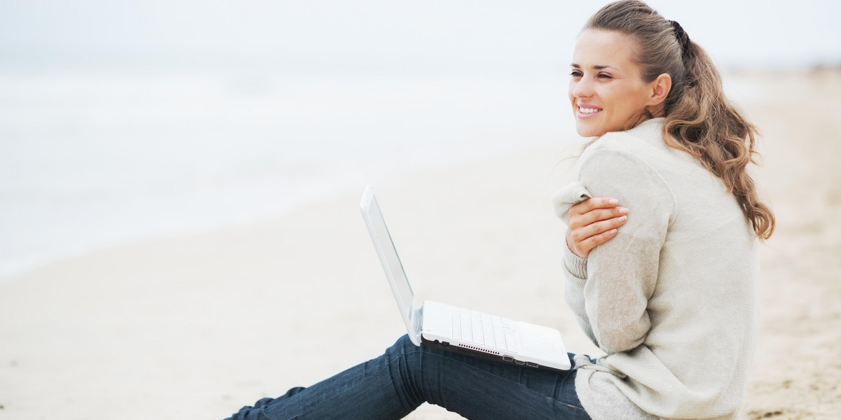 kobieta z laptopem na plaży