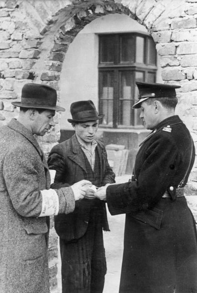 Granatowy policjant kontroluje dokumenty w getcie, 1941. Źródło: Bundesarchiv/Wikimedia Commons.