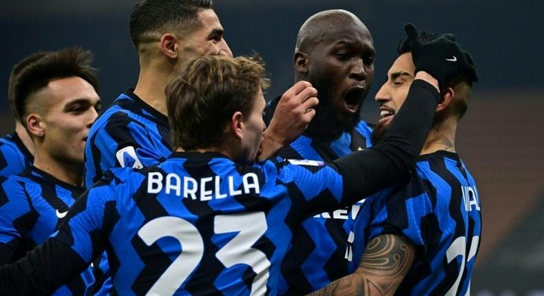 Inter Milan midfielder Arturo Vidal (R) and Nicolo Barella (C) celebrate after scoring against Juventus.