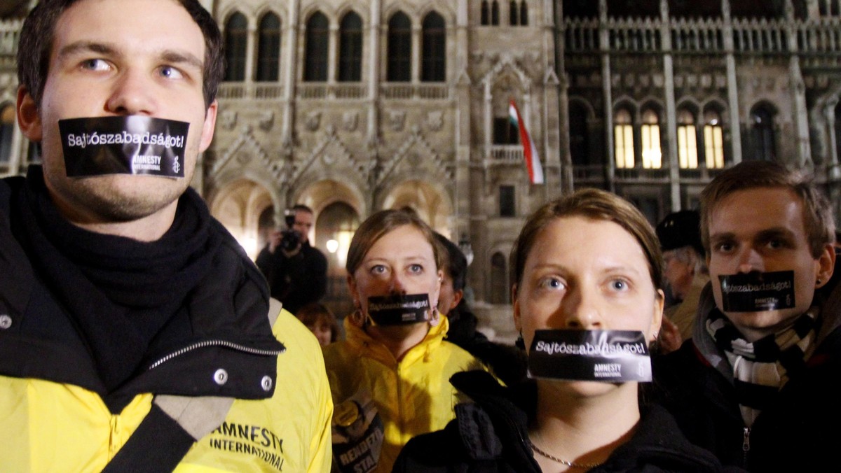 Hungarians, with stickers on their mouth, take part in a demonstration against the government's new 