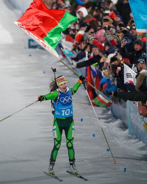 Darja Domračeva sa beloruskom zastavom prolazi prva kroz cilj