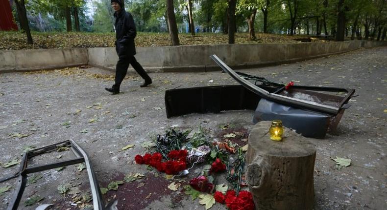 A man walks past flowers left in memory of pro-Russian rebel commander Arseny Pavlov, known as Motorola, in Donetsk on October 17, 2016