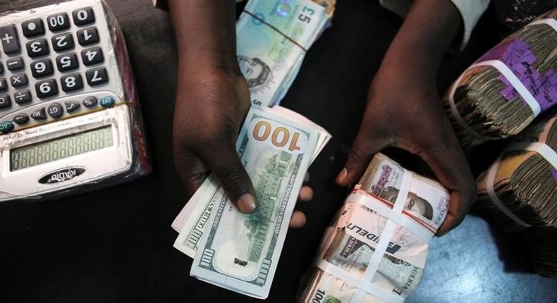 A trader changes dollars for naira at a currency exchange store in Lagos, Nigeria, February 12, 2015.   REUTERS/Joe Penney/File Photo