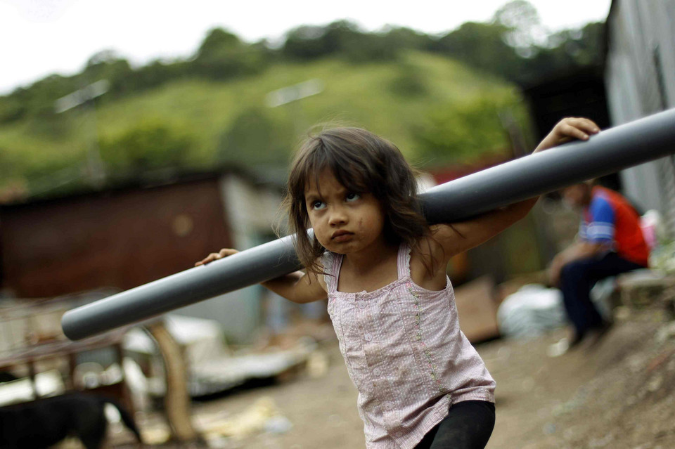 A girl carries a plastic tube during an evacuation in the Barrio del Carmen slum near San Jose November 10, 2010.