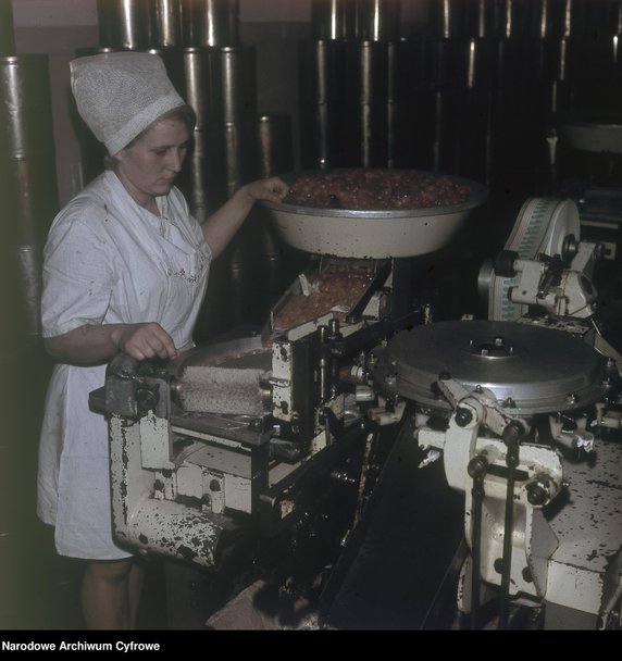 Kobieta pracująca przy maszynie służącej do automatycznego zawijania cukierków w papierki. Fabryka Cukrów i Czekolady "Ślązak" w Raciborzu - 1970 r. - Narodowe Archiwum Cyfrowe