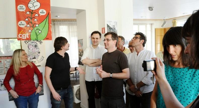 File picture shows cartoonist Catherine Meurisse (R) at an editorial meeting at the Paris office of French satirical magazine Charlie Hebdo