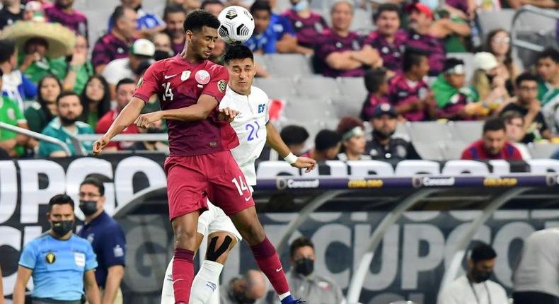 Qatar's Homam Ahmed, left, battles for a header with El Salvador's Bryan Tamacas during the Concacaf Gold Cup quarter-final match in Arizona Creator: Frederic J. BROWN