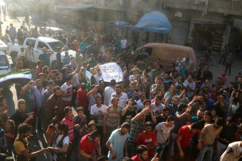 People carrying a Free Syrian Army flag and a Jabhat Fatah al-Sham flag on Saturday while celebrating the breaking of the siege of rebel-held areas of Aleppo.