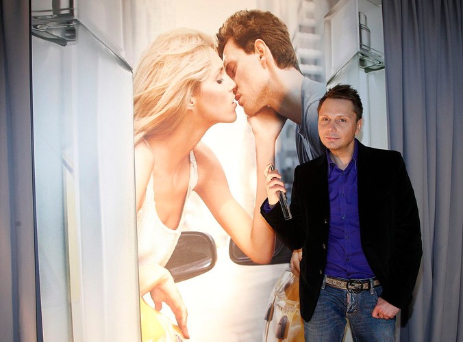 Fryzjer Robert Krupiński na tle zdjęcia Anji i Sashy